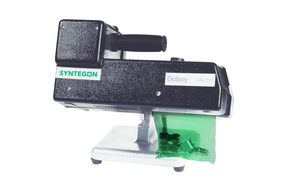 Doboy HS-CII hand-fed band sealer on its pedestal stand, sealing the neck of a green bag, with the Doboy HS-C II model badge on the housing