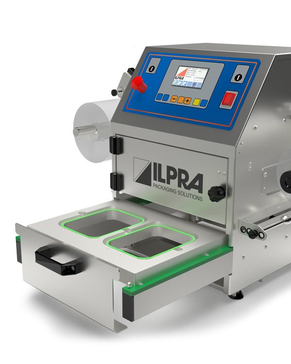 Ilpra FoodPack Basic tray sealer with two trays loaded in the drawer and the film reel on the side of the sealing head
