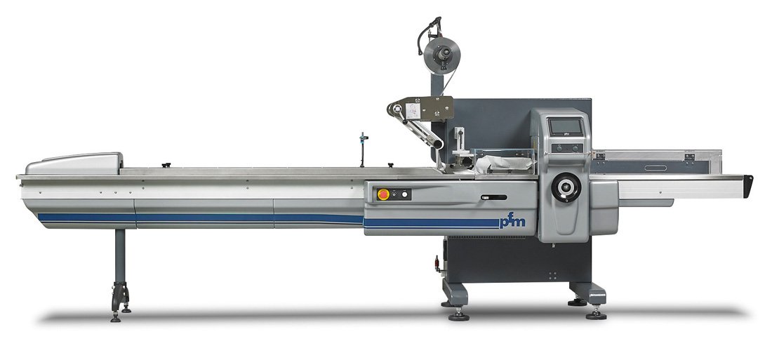 PFM Pearl horizontal flow wrapper with the infeed conveyor running the length of the machine to the crimp jaws