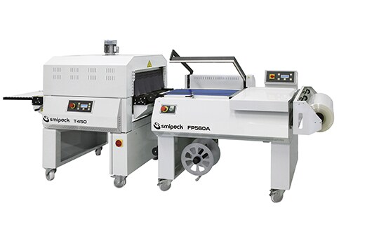 Smipack FP560A L-bar sealer with the seal frame raised, paired with a Smipack T450 shrink tunnel, both carrying their model badges