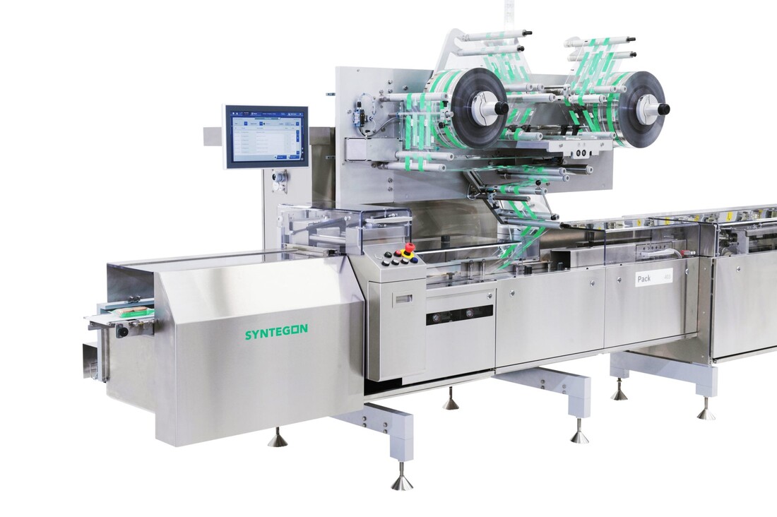 Horizontal form-fill-seal flow wrapper with film reels feeding over the fin wheels into the crimp jaws