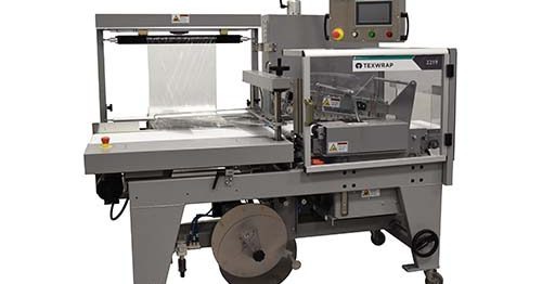 Texwrap TLS 2219 L-bar sealer with the film sheet raised over the infeed conveyor and the 2219 model badge on the frame