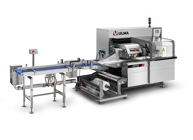 ULMA Artic horizontal flow wrapper on its stainless steel frame with the infeed conveyor and film reel in place